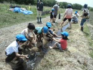 画像：あぜ道を流れるセキで泥んこを洗います